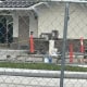 Fostoria News Construction site behind a chain-link fence with orange cones and building materials.